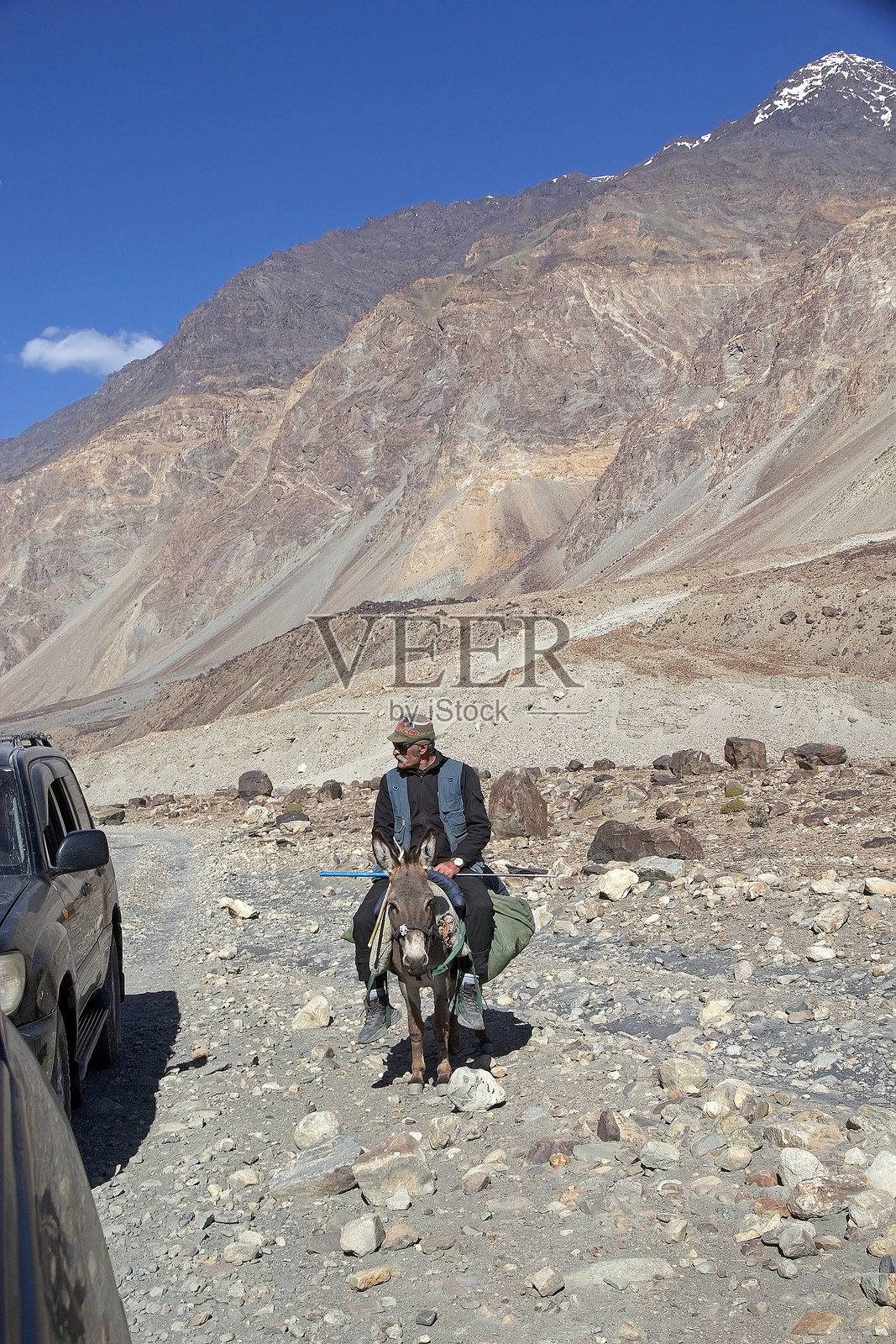 塔吉克斯坦戈尔诺-巴达赫尚地区巴尔唐谷中的驴子和男人照片摄影图片