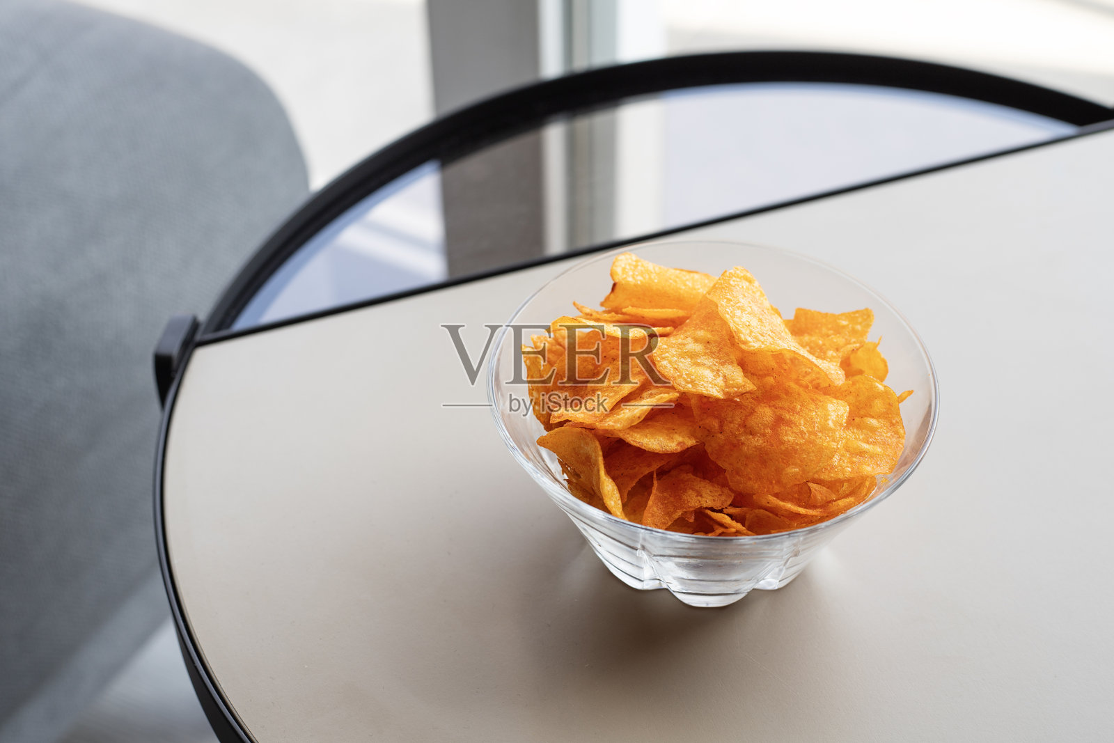 桌子上的碗里装着撒有红椒粉的薯片照片摄影图片
