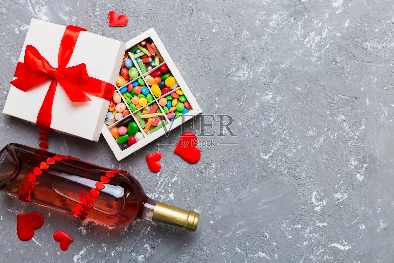 情人节背景下的红酒瓶、礼物和巧克力。心形巧克力礼盒的俯视图，留有空白空间。照片摄影图片