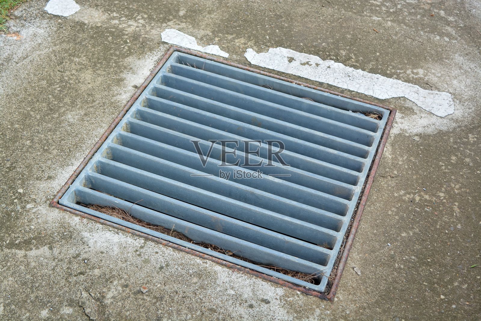 图像显示了嵌入混凝土表面的金属排水格栅。照片摄影图片