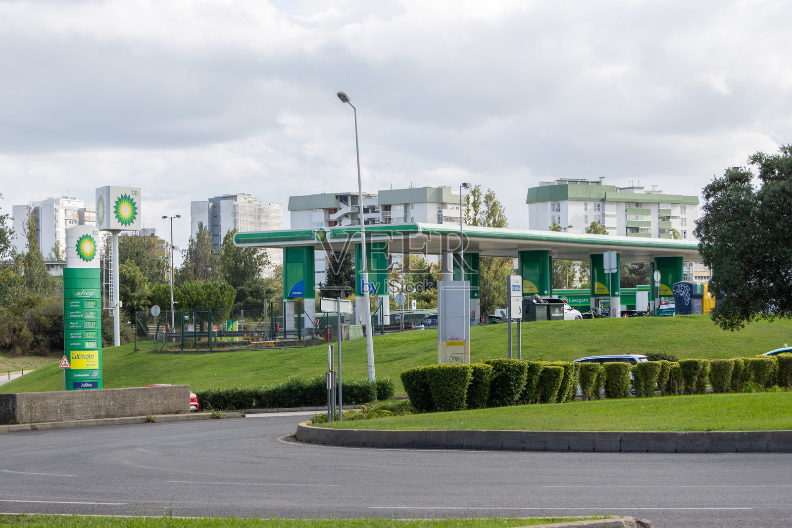 BP加油站,背景是阴天的住宅楼照片摄影图片