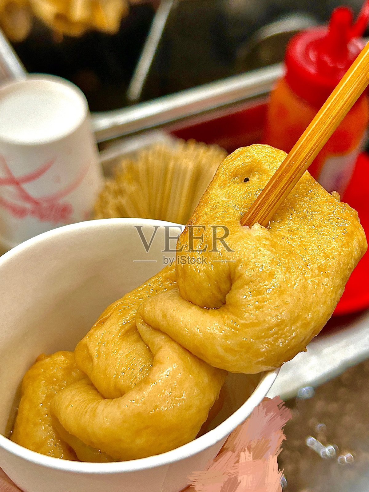 Odeng是一种受欢迎的韩国街头小吃，由调味鱼饼制成，串在竹签上，浸泡在温暖的咸汤中。通常搭配蘸酱，是一种随时都能享用的舒适美味小吃。照片摄影图片