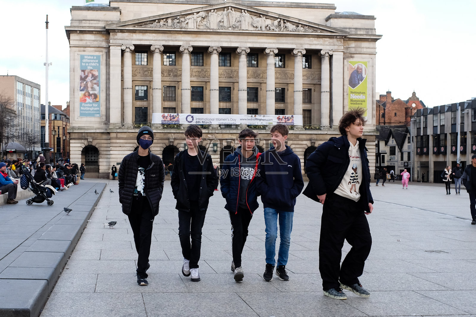 年轻人在广场上散步。照片摄影图片