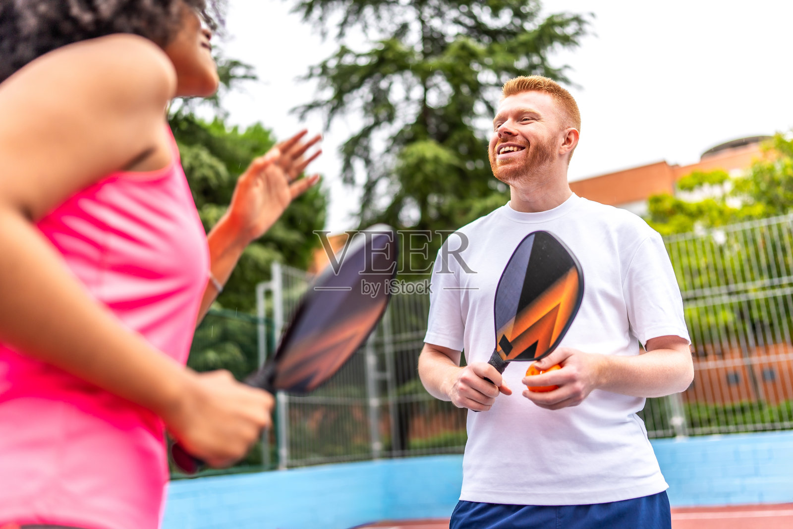 多民族情侣在户外球场打皮克球照片摄影图片