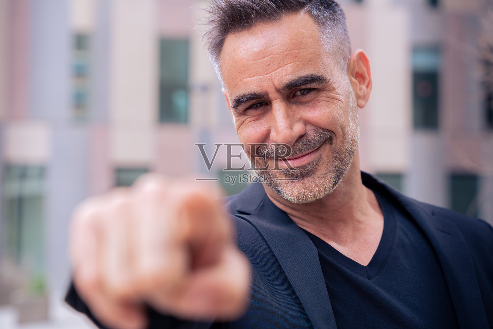 自信微笑的商务人士在户外指向前方并看向镜头照片摄影图片