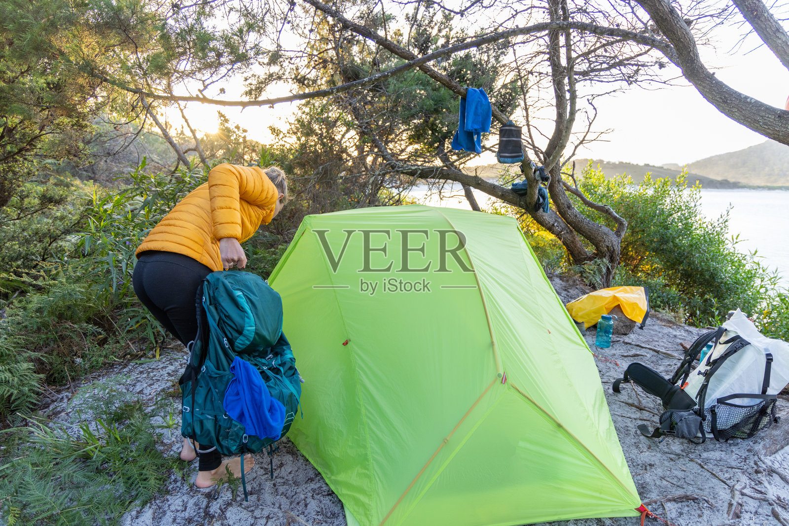 女人在森林露营地搭帐篷照片摄影图片