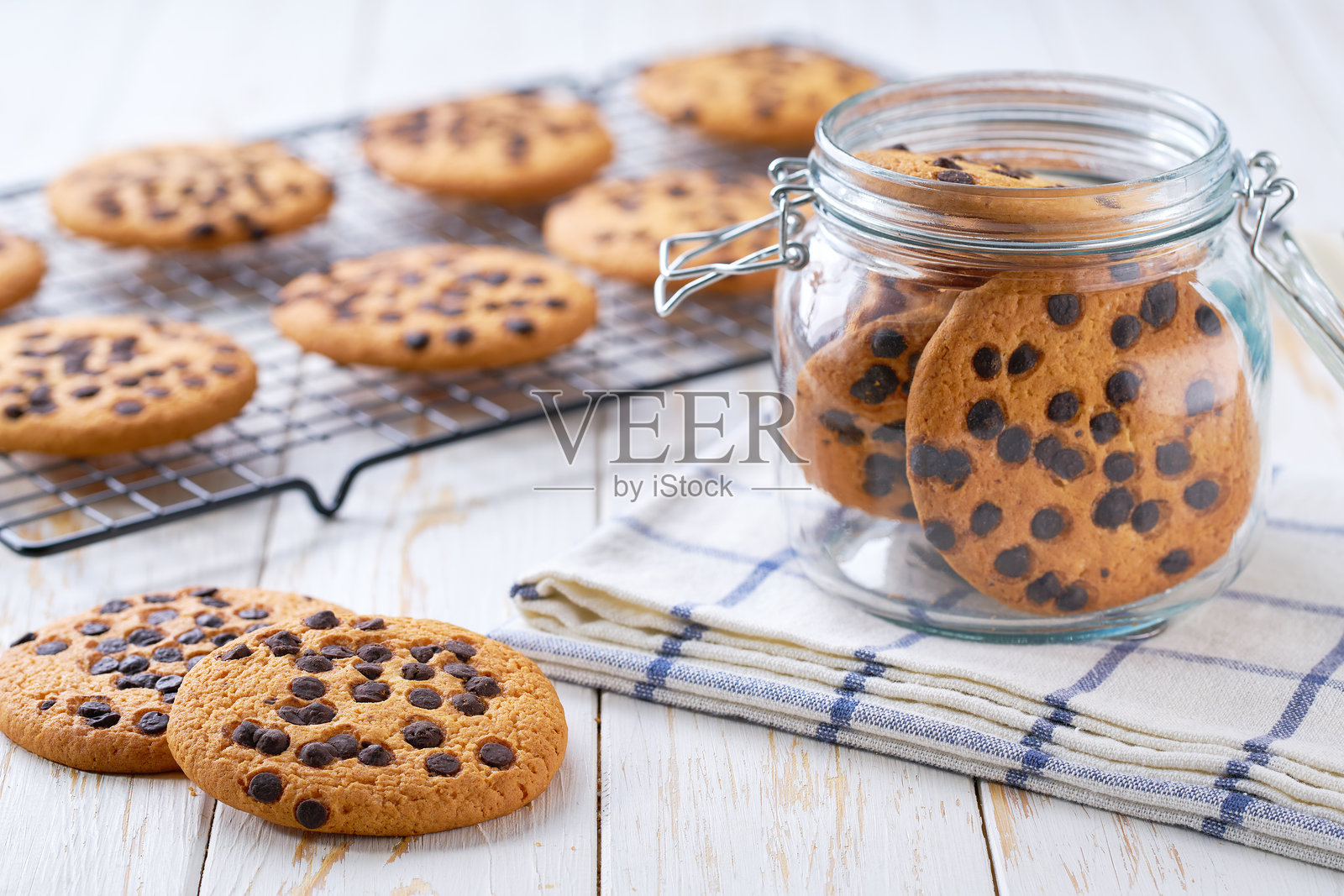 白色木桌上的巧克力曲奇饼干，选择性对焦。照片摄影图片