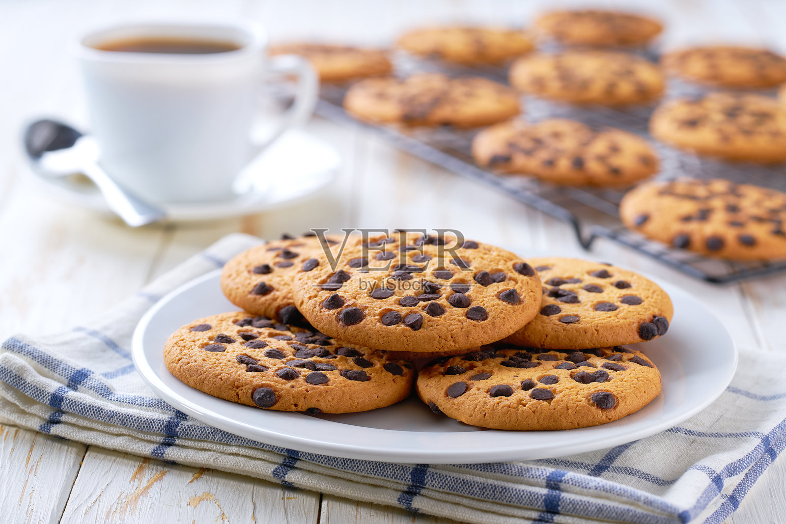 白色桌子上的巧克力曲奇饼干和咖啡，选择性对焦。照片摄影图片