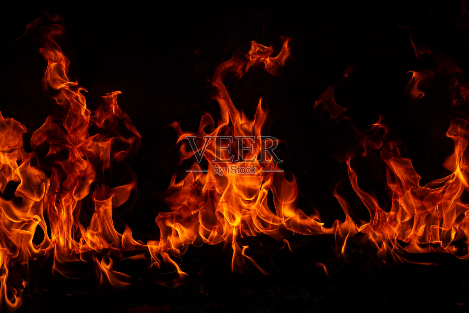 黑色背景上的火焰。火焰燃烧，孤立的抽象纹理。燃烧火焰的效果。照片摄影图片