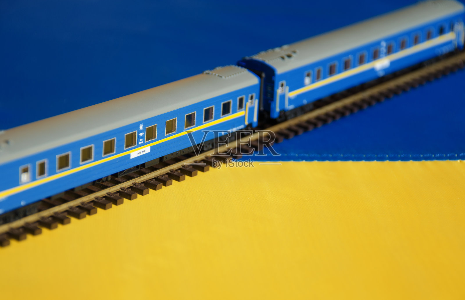 利沃夫-基辅客运列车模型与乌克兰国旗背景。照片摄影图片