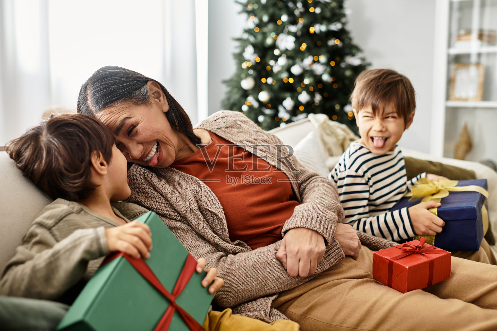 快乐的亚洲家庭在现代客厅中享受温馨的圣诞庆祝活动照片摄影图片