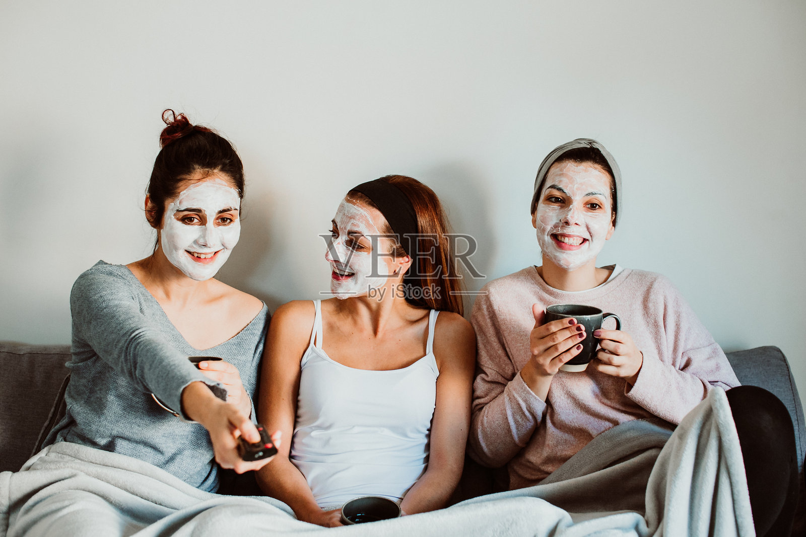 在家沙发上坐着的女性，戴着面膜照片摄影图片