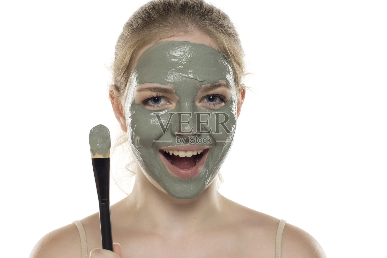 美丽的年轻女性面部涂抹绿色泥浆面膜，展现护肤和治疗，水疗，自然美和美容概念。照片摄影图片
