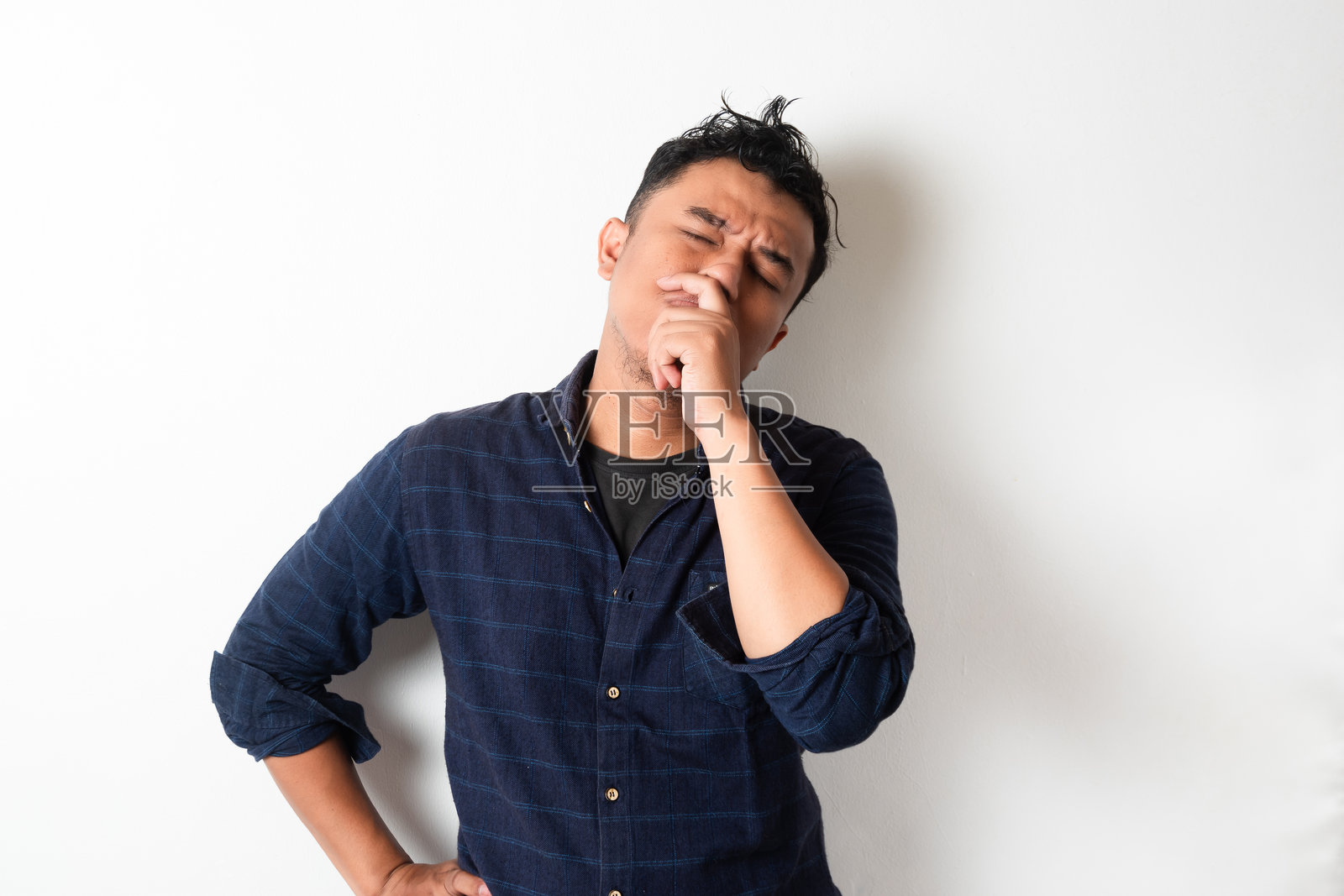 穿着深蓝色法兰绒衬衫的亚洲成年男性做出思考的手势照片摄影图片