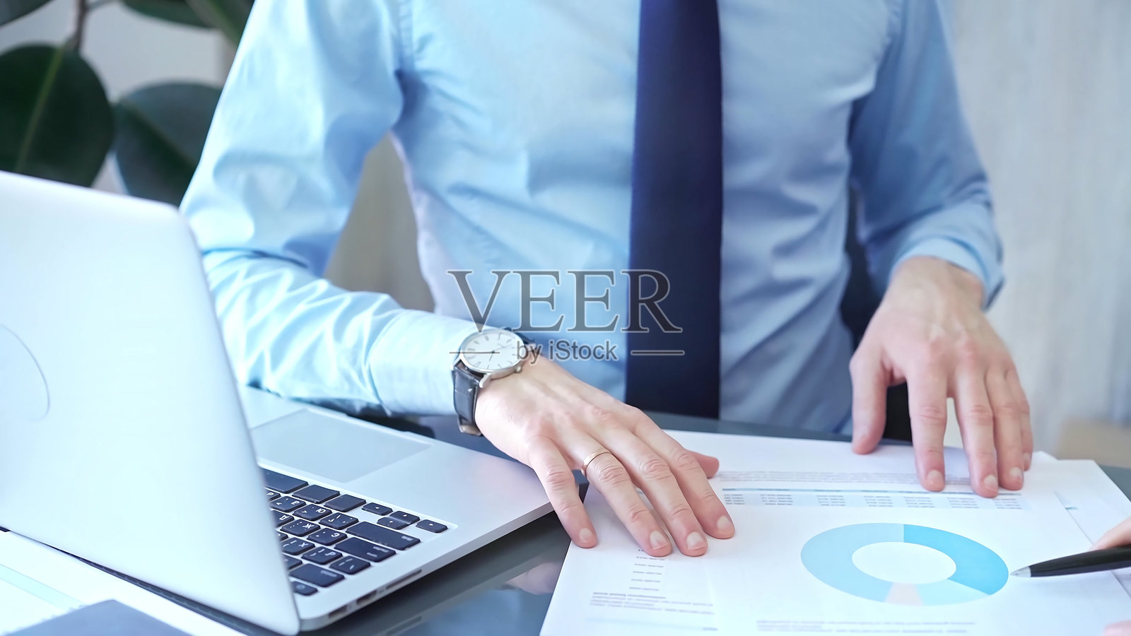 现代办公室中，一位男商人和女商人在玻璃桌旁分析数据，近距离视角。商业概念照片摄影图片