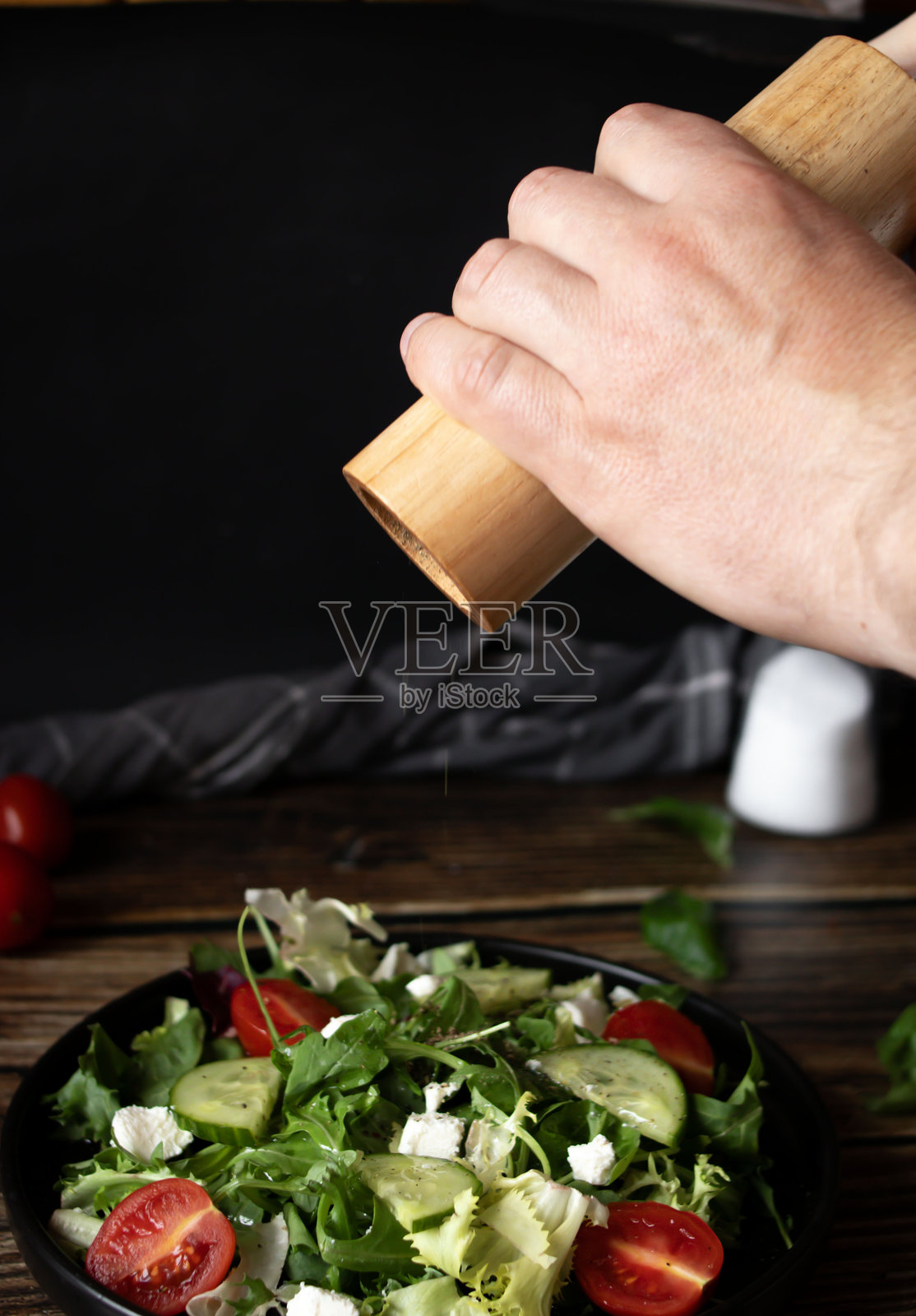 新鲜的沙拉，配有芝麻菜、樱桃番茄和菲达奶酪，背景为木质桌面。健康食品。照片摄影图片