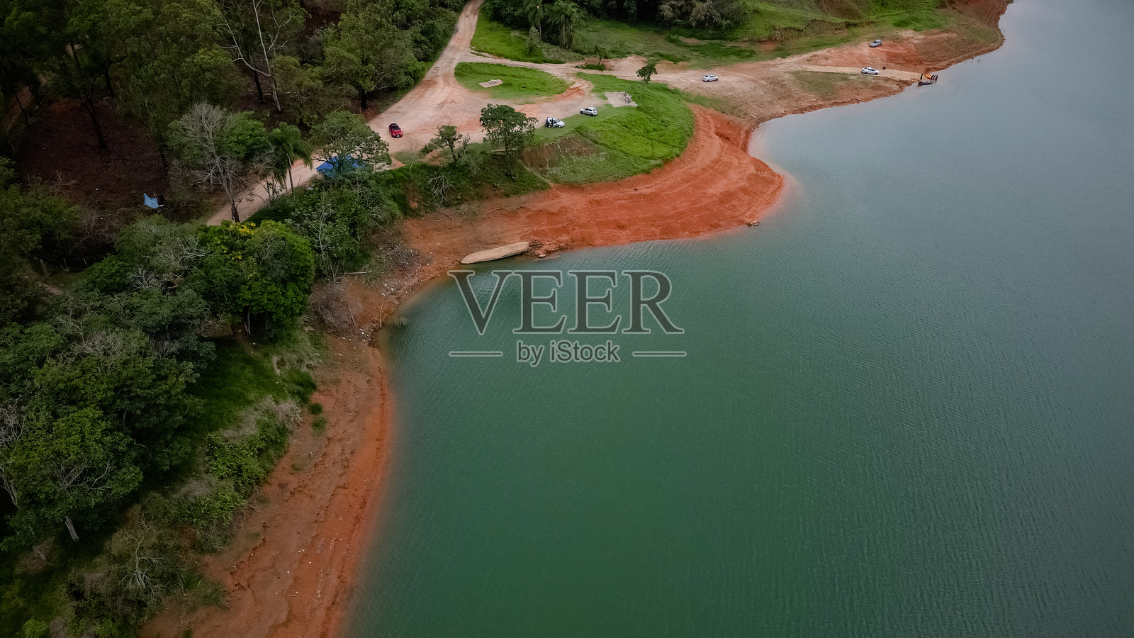 从上方用无人机拍摄的完整水坝，水位较低，背景是自然风光。照片摄影图片