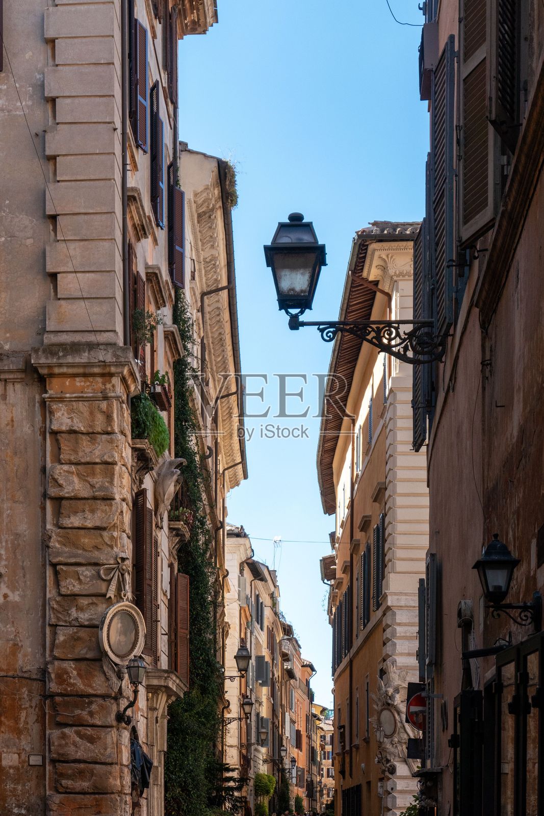 罗马迷人的狭窄街道，旁边是历史悠久的建筑。照片摄影图片