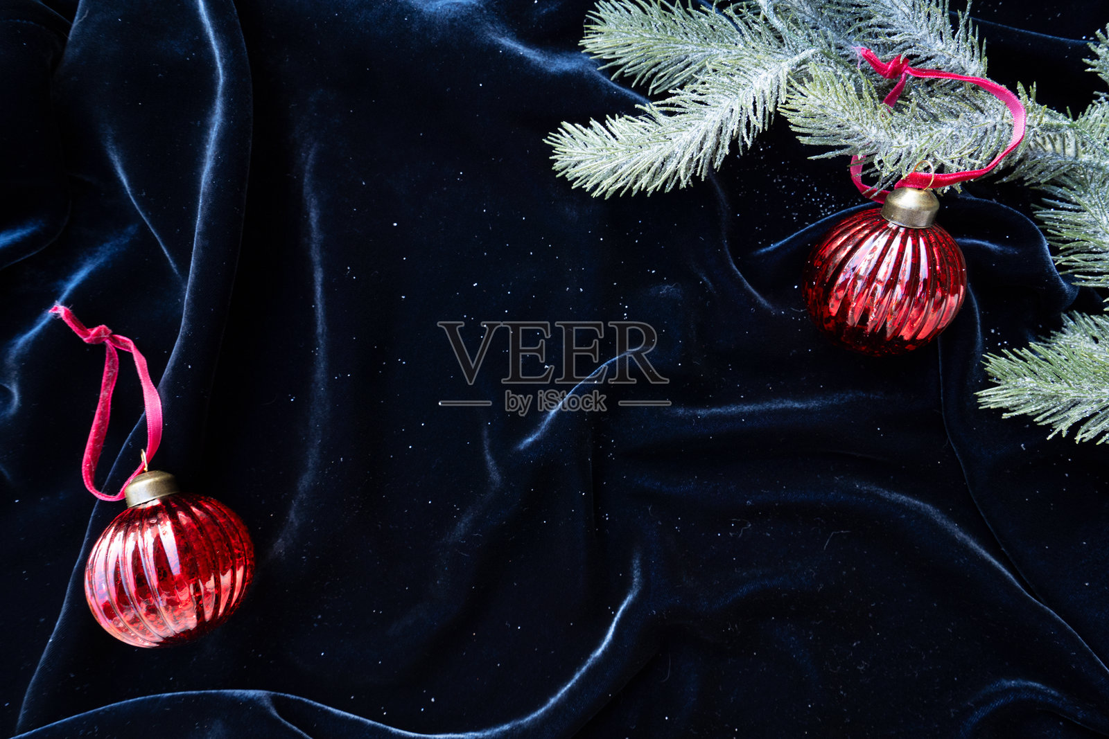 一个装有复古圣诞装饰品的盒子展示在银色布料背景上，营造出节日的氛围。照片摄影图片