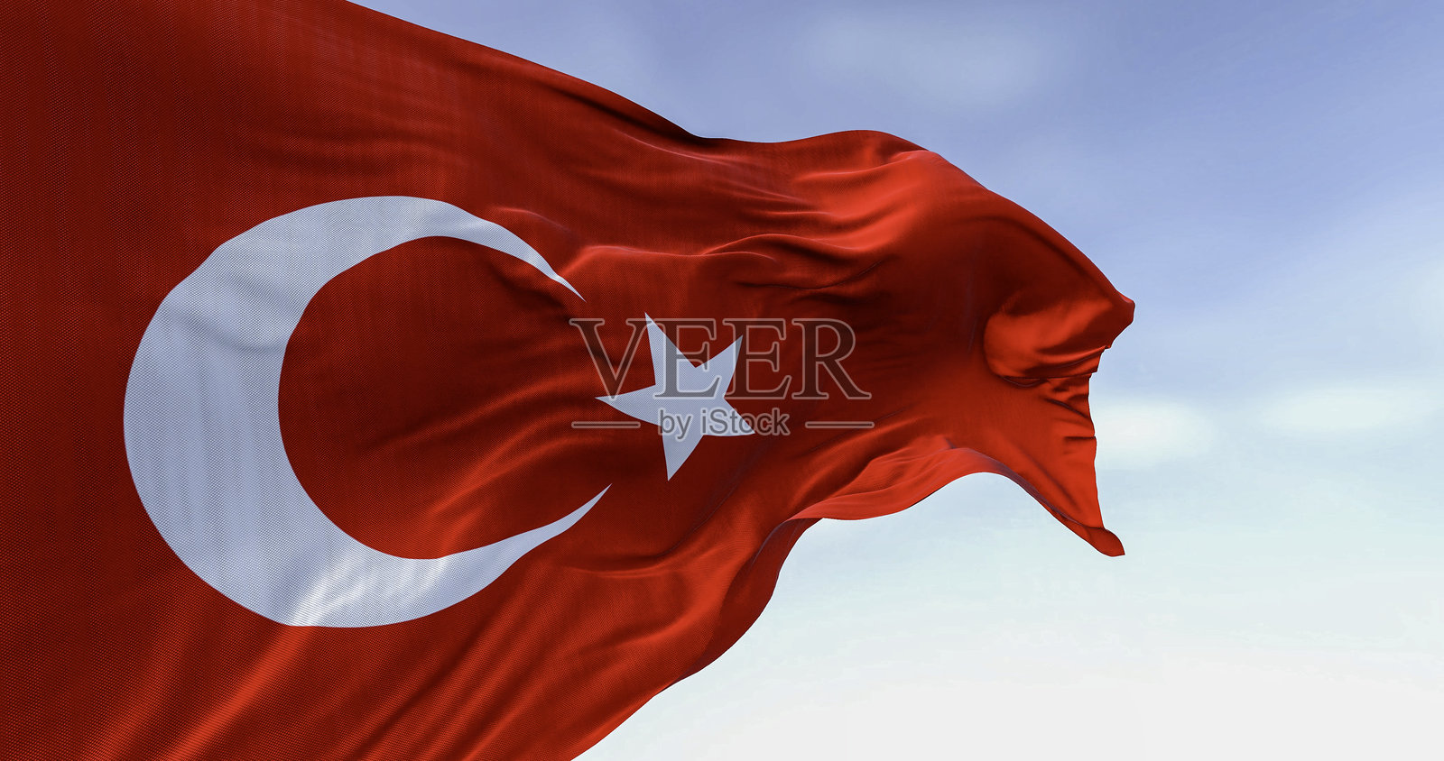 在晴朗的日子里，土耳其国旗在风中飘扬照片摄影图片