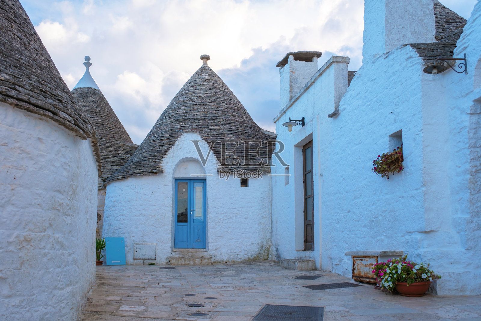 意大利普利亚地区迷人的特鲁利房屋在黄昏时分的戏剧性天空下照片摄影图片