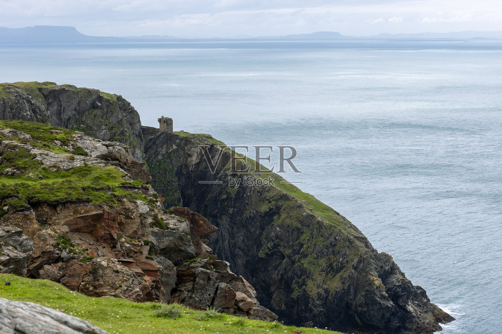 卡里根头信号塔坐落在爱尔兰斯利夫联盟附近的悬崖上，俯瞰着广阔的海洋和崎岖的海岸线。照片摄影图片