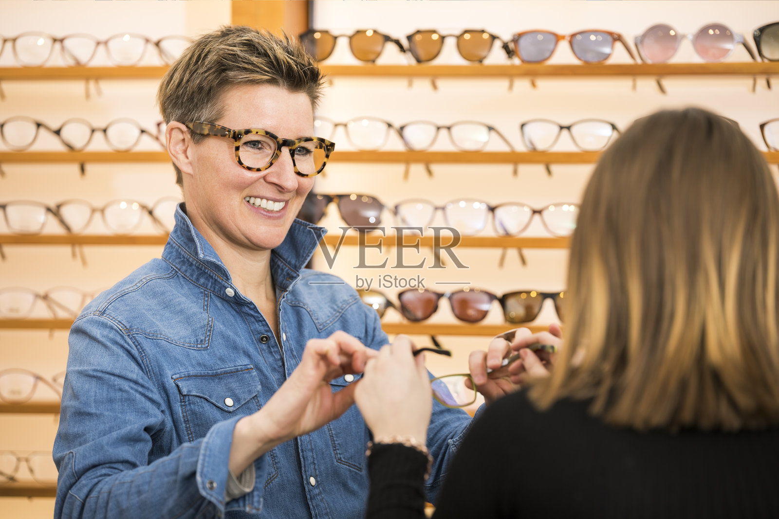 成熟的女性与顾客在商店内照片摄影图片