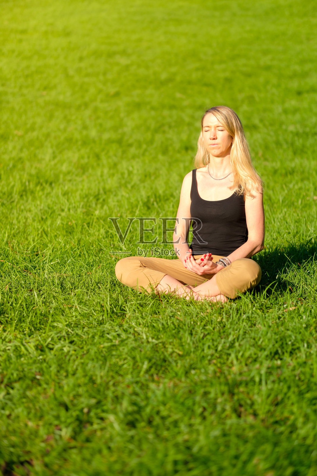 女人坐在大自然中冥想，进行接地/大地疗法。照片摄影图片