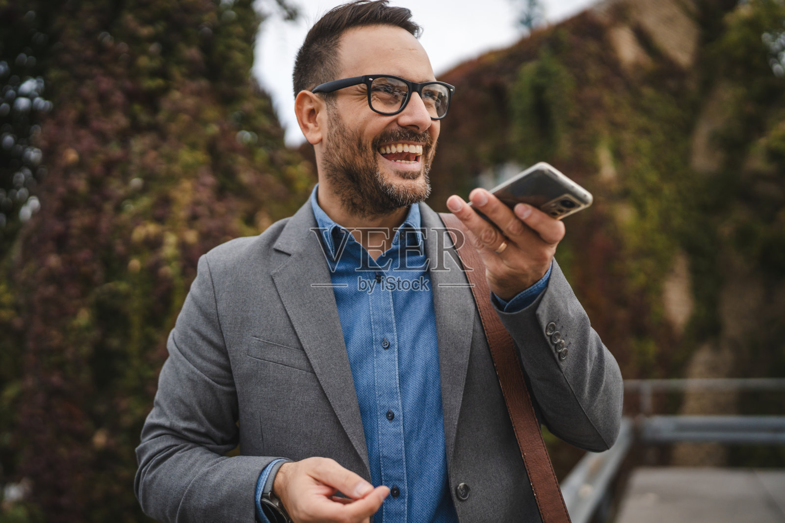 成年男性商人在手机上留下语音留言照片摄影图片