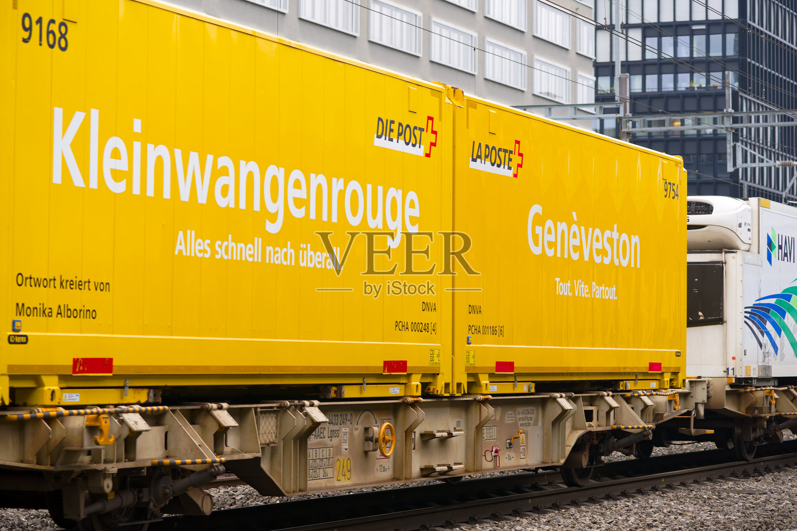 在雾蒙蒙的秋日中午,黄色瑞士邮政集装箱的货运列车在瑞士苏黎世阿尔特斯滕火车站经过特写镜头。照片摄影图片