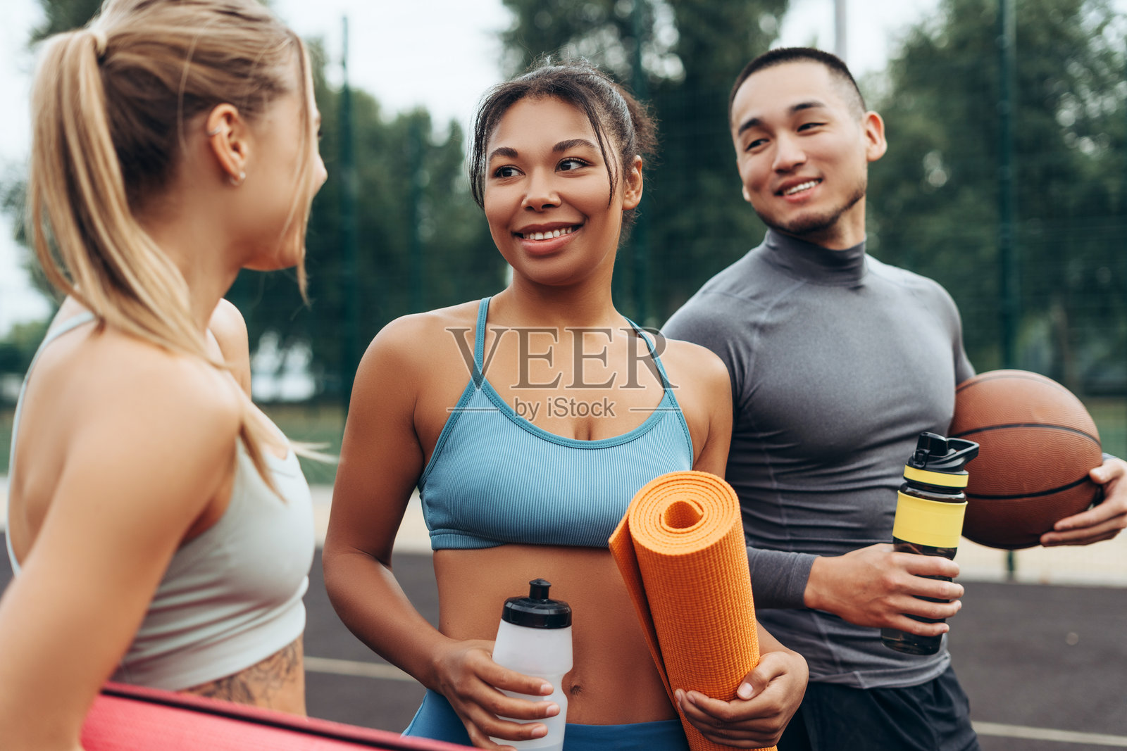 一群微笑、快乐的多种族人士，运动员和女运动员一起交谈、训练。照片摄影图片