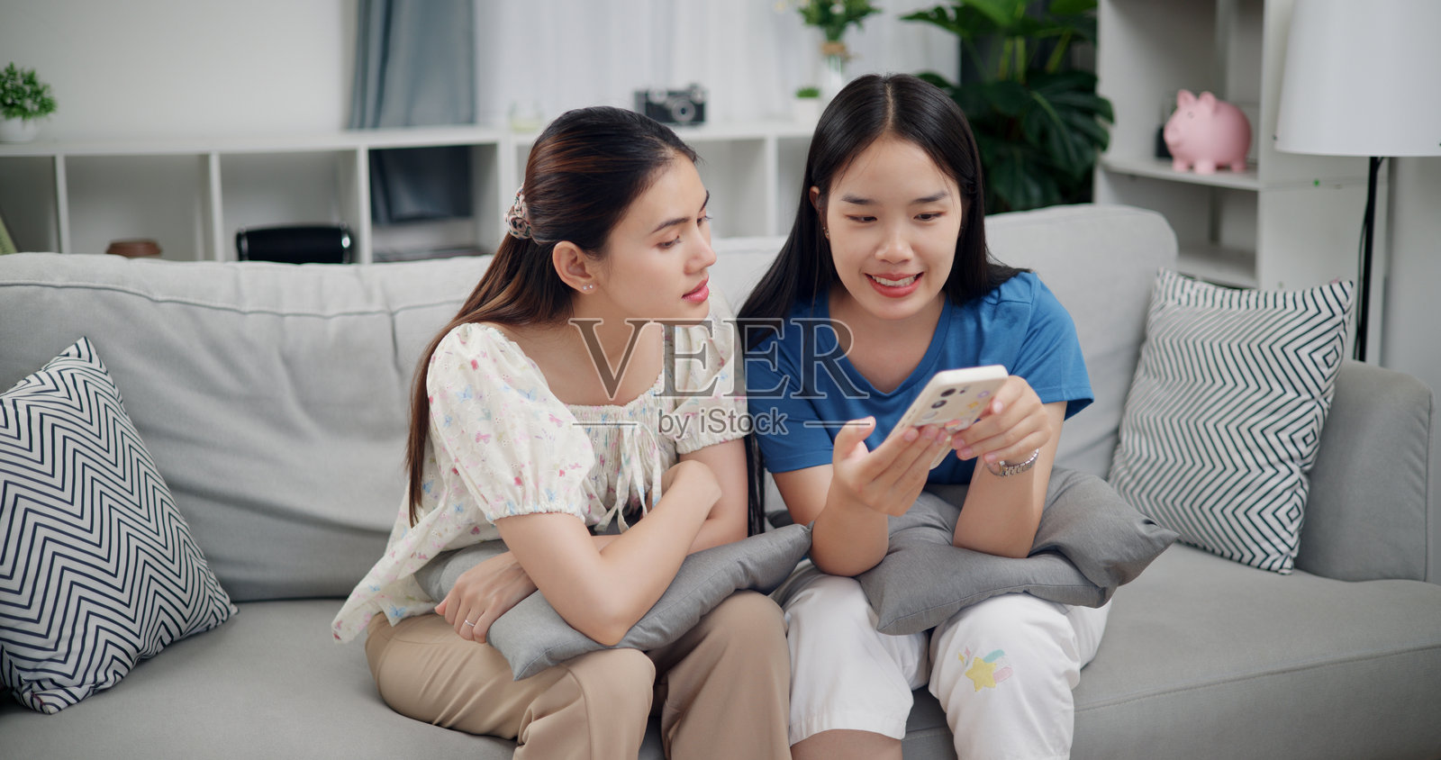 两个兄妹正在一起用手机观看搞笑视频片段。照片摄影图片