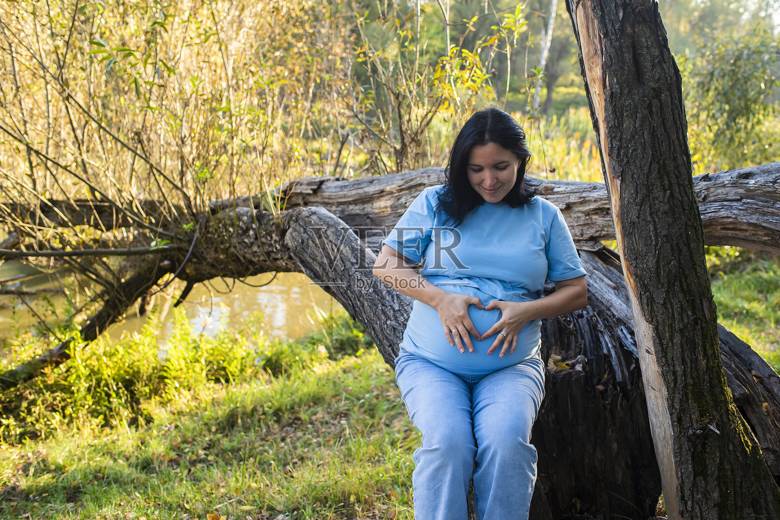 42岁孕妇在秋季公园。40岁后晚期妊娠。照片摄影图片