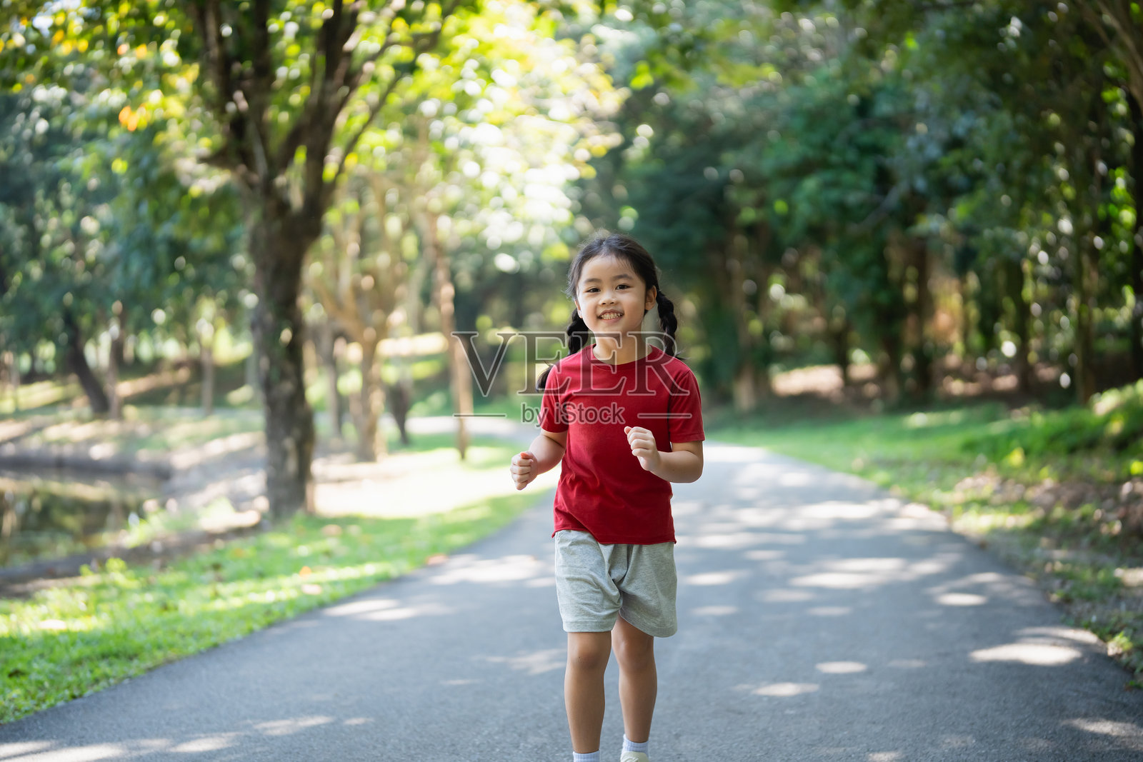 快乐的亚洲小女孩微笑。小女孩在日落时奔跑并微笑。快乐的小女孩微笑。小宝宝在日落时奔跑。可爱的小宝宝在游乐场花园里奔跑。照片摄影图片
