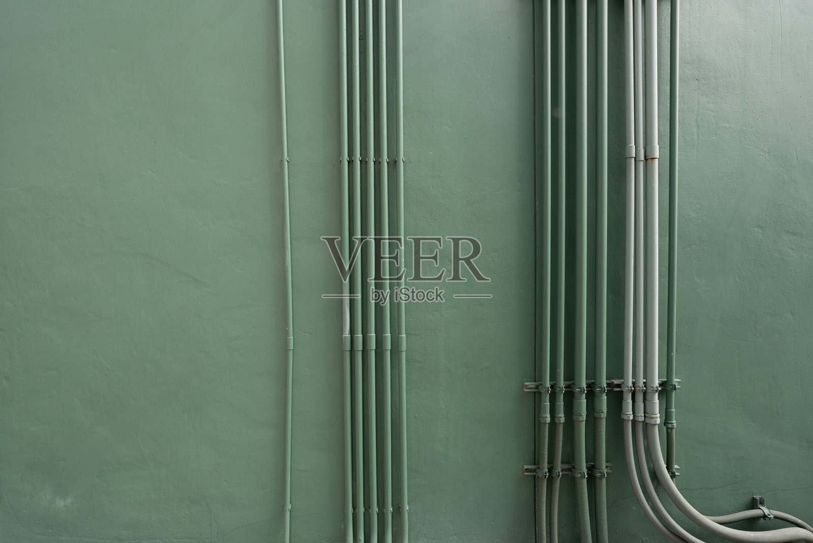 建筑墙上的电缆管道系统，配有管道和电缆。现代建筑中高效安全的电力分配基础设施管理。电缆组织。照片摄影图片