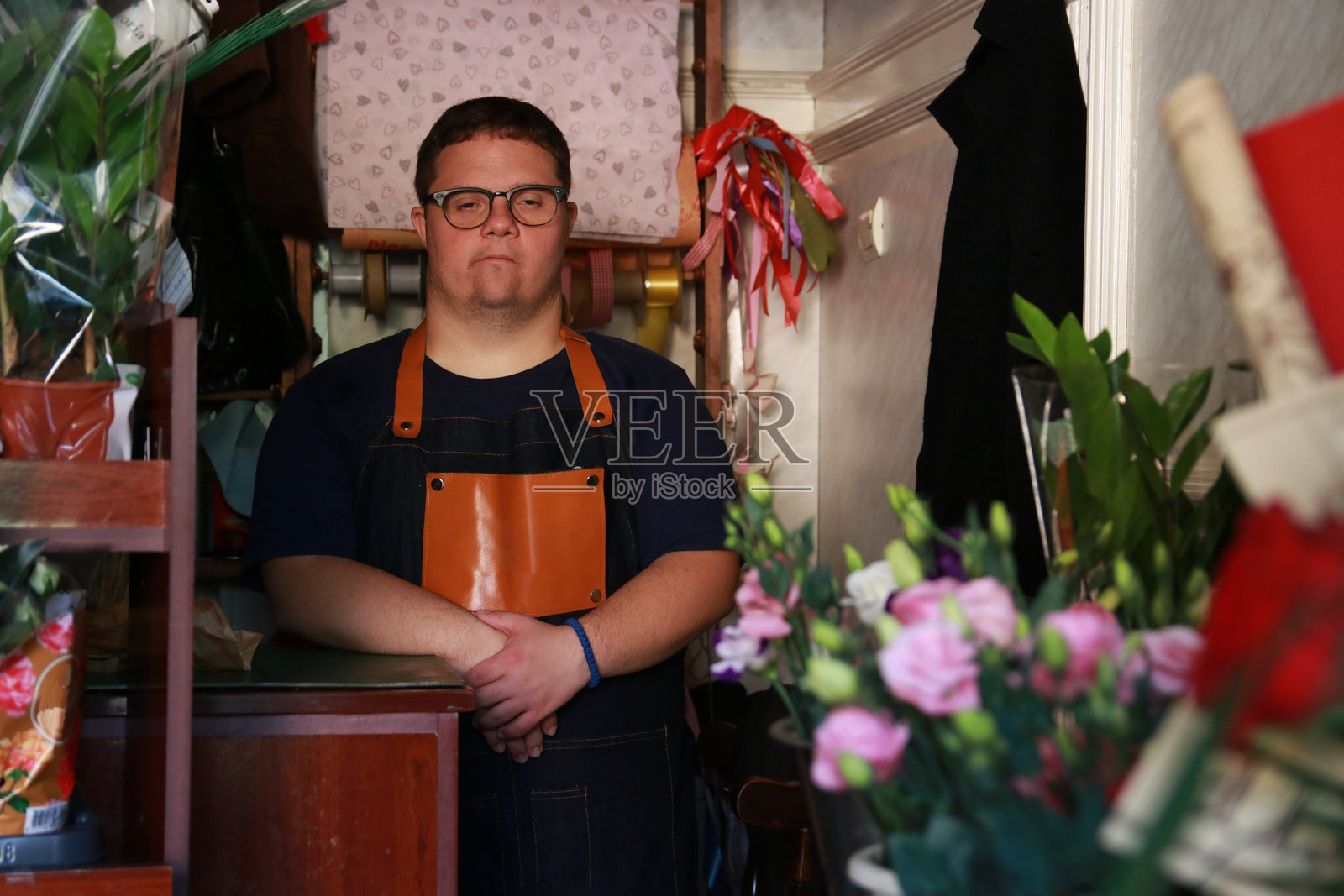 残疾年轻人在花店工作照片摄影图片
