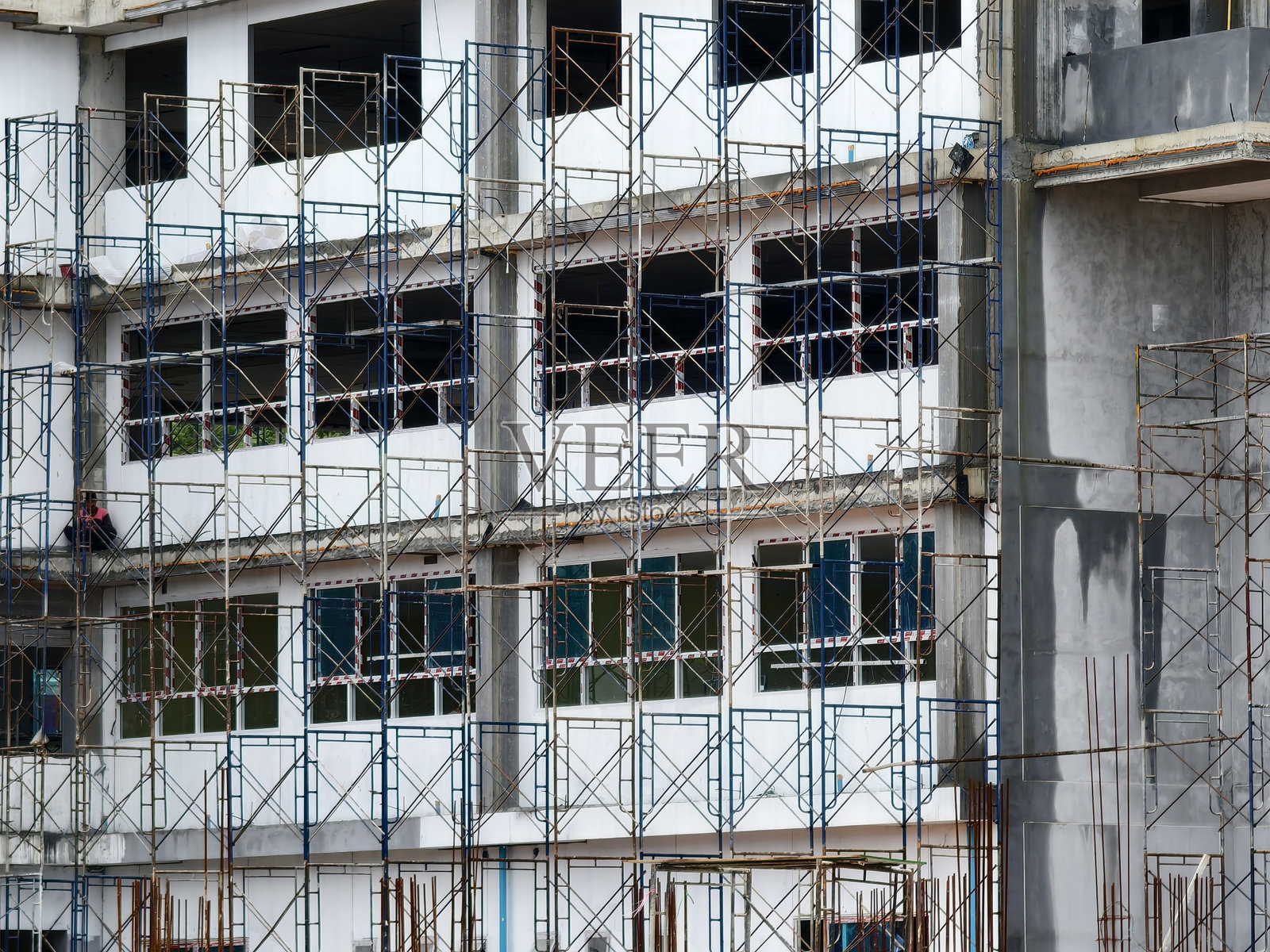 一座高楼正在建设中，拥有众多窗户。照片摄影图片