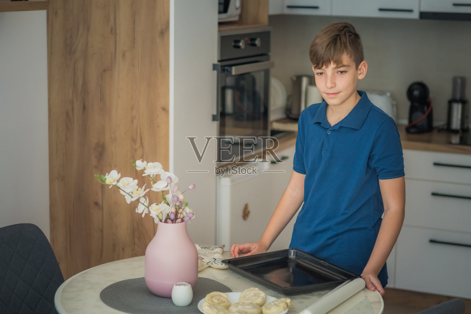 少年在厨房独自准备和烘焙美味的糕点。没有成年人的帮助进行烹饪。在上学前制作小吃或餐点。照片摄影图片