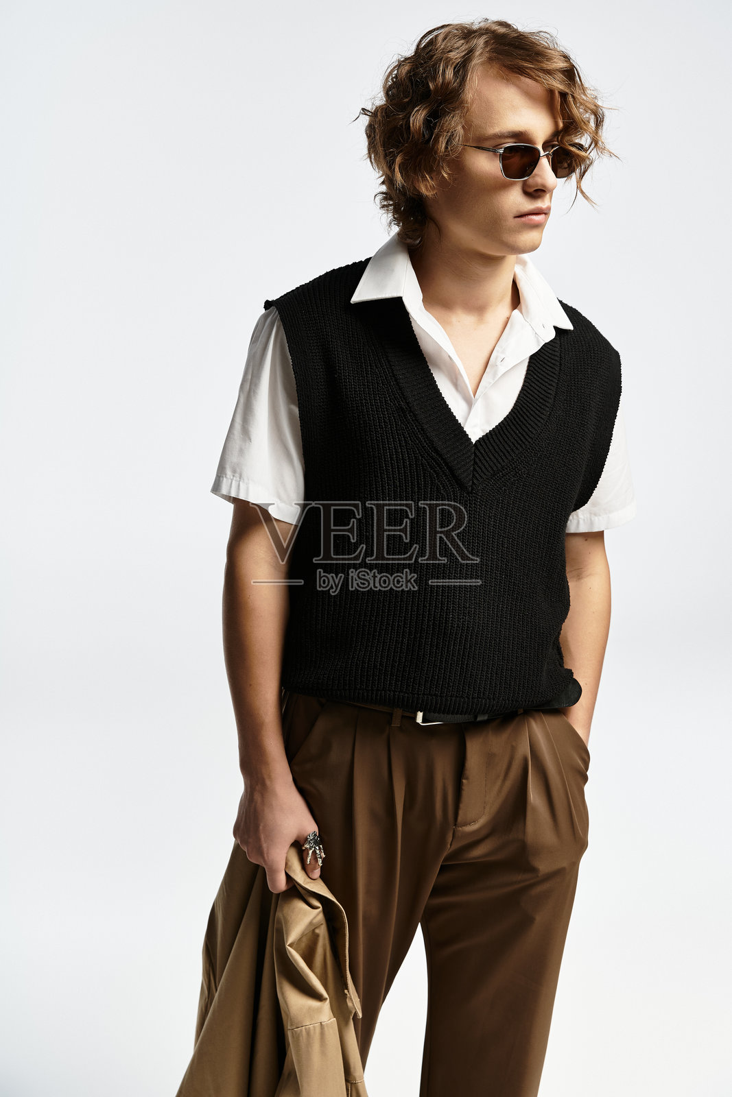 时尚年轻男子穿着别致的秋季服装，在工作室氛围中优雅地摆姿势照片摄影图片