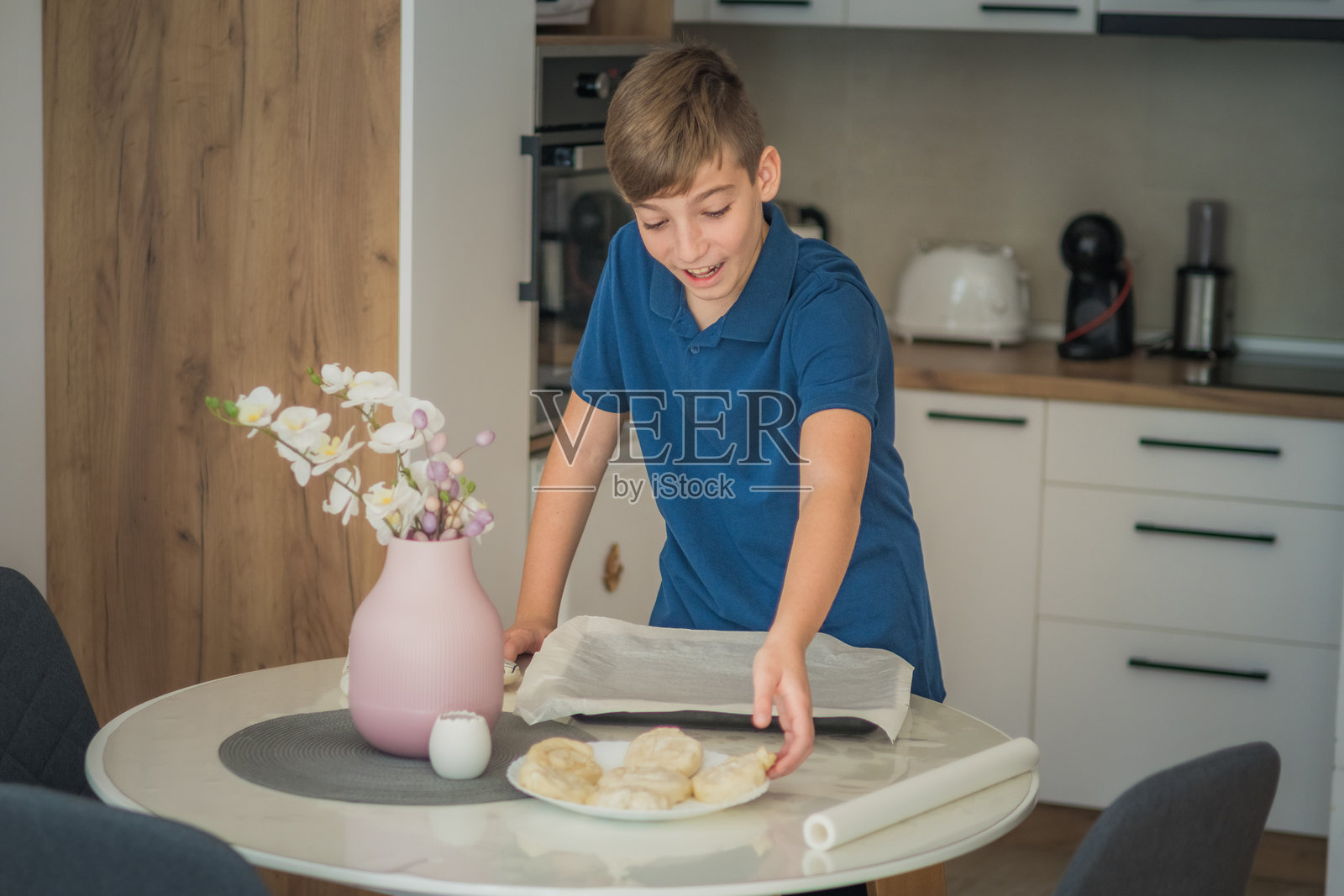 少年在厨房独自准备和烘焙美味的糕点。没有成年人的帮助进行烹饪。在上学前制作零食或餐点。照片摄影图片