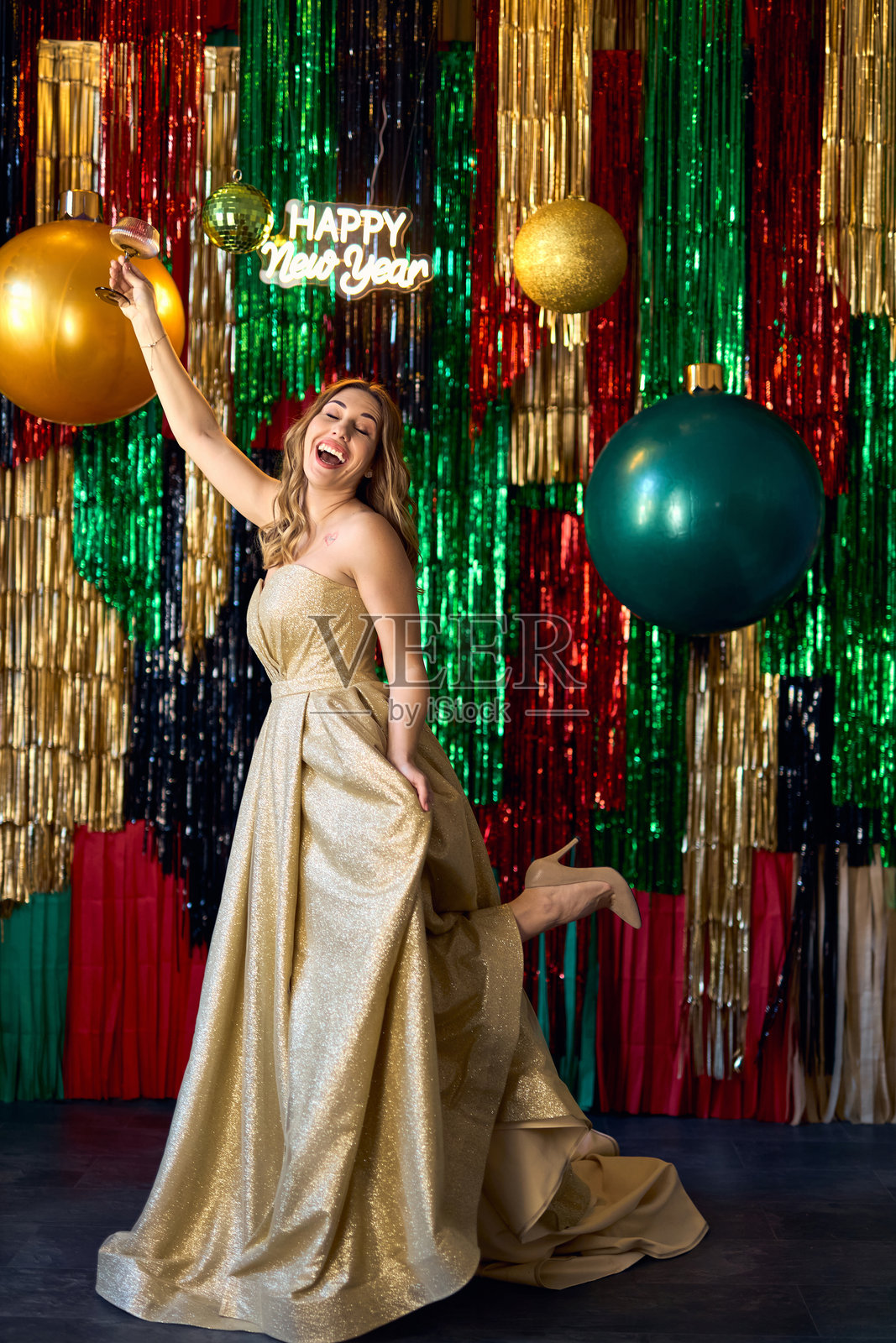 身穿奢华金色礼服的女性与香槟照片摄影图片