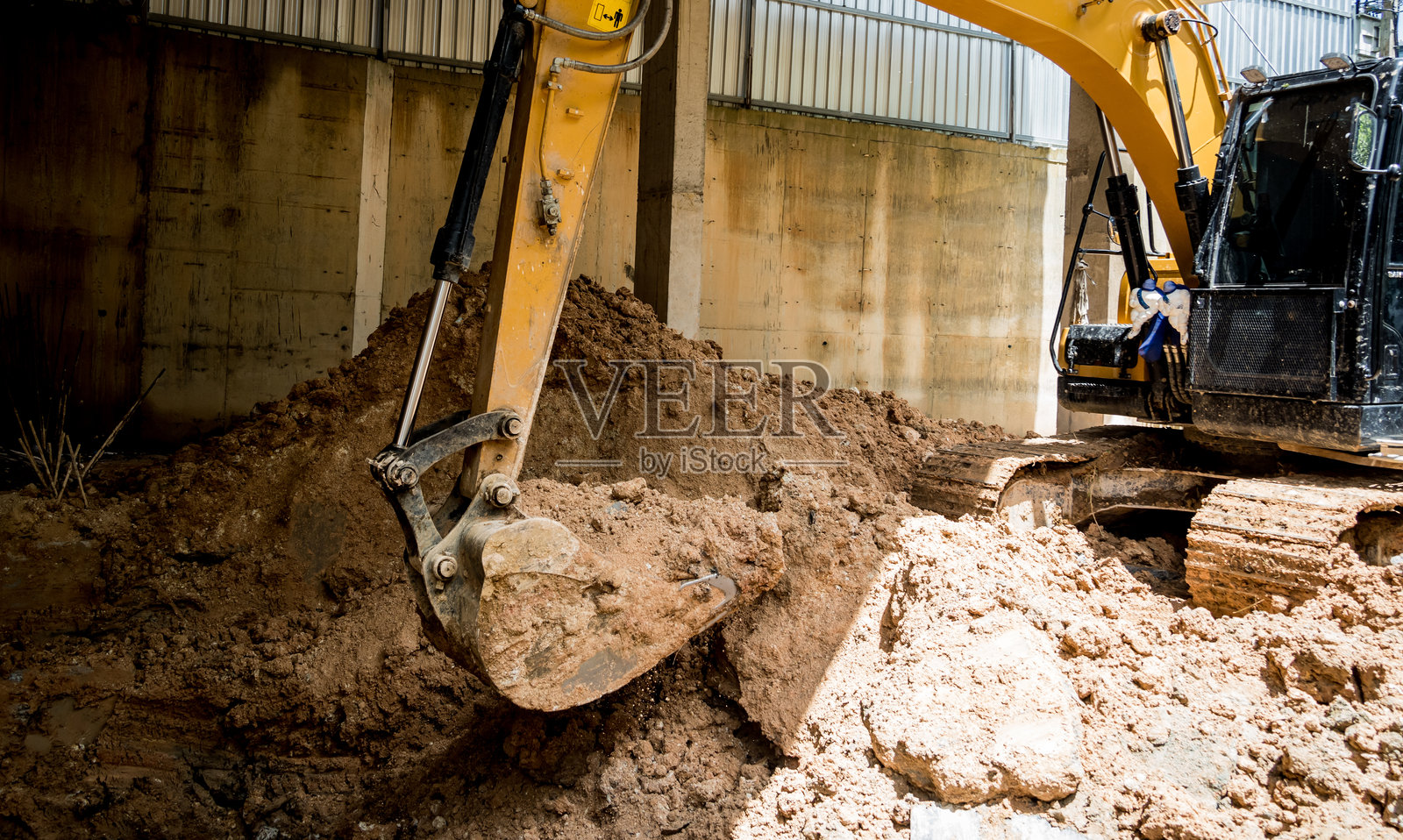 一台推土机正在挖掘一大堆土壤。照片摄影图片