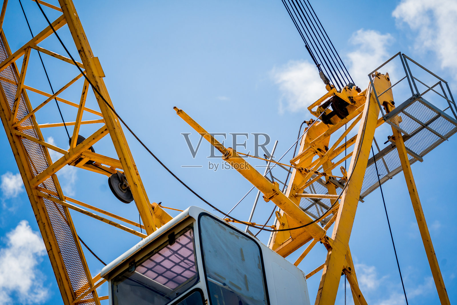 一台大型黄色起重机在明亮的蓝天中格外显眼照片摄影图片