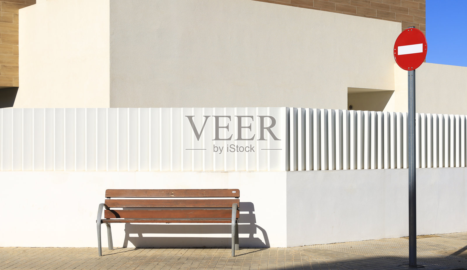 现代房屋前的木长椅，旁边有禁止通行的信号。照片摄影图片