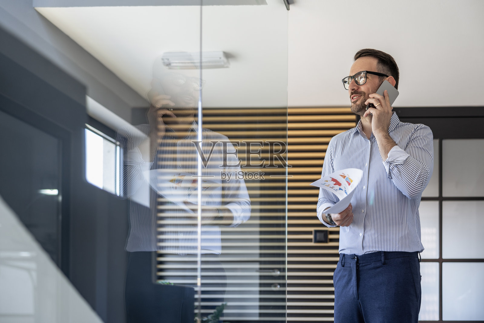 现代办公室中与电话交谈的职业商人照片摄影图片