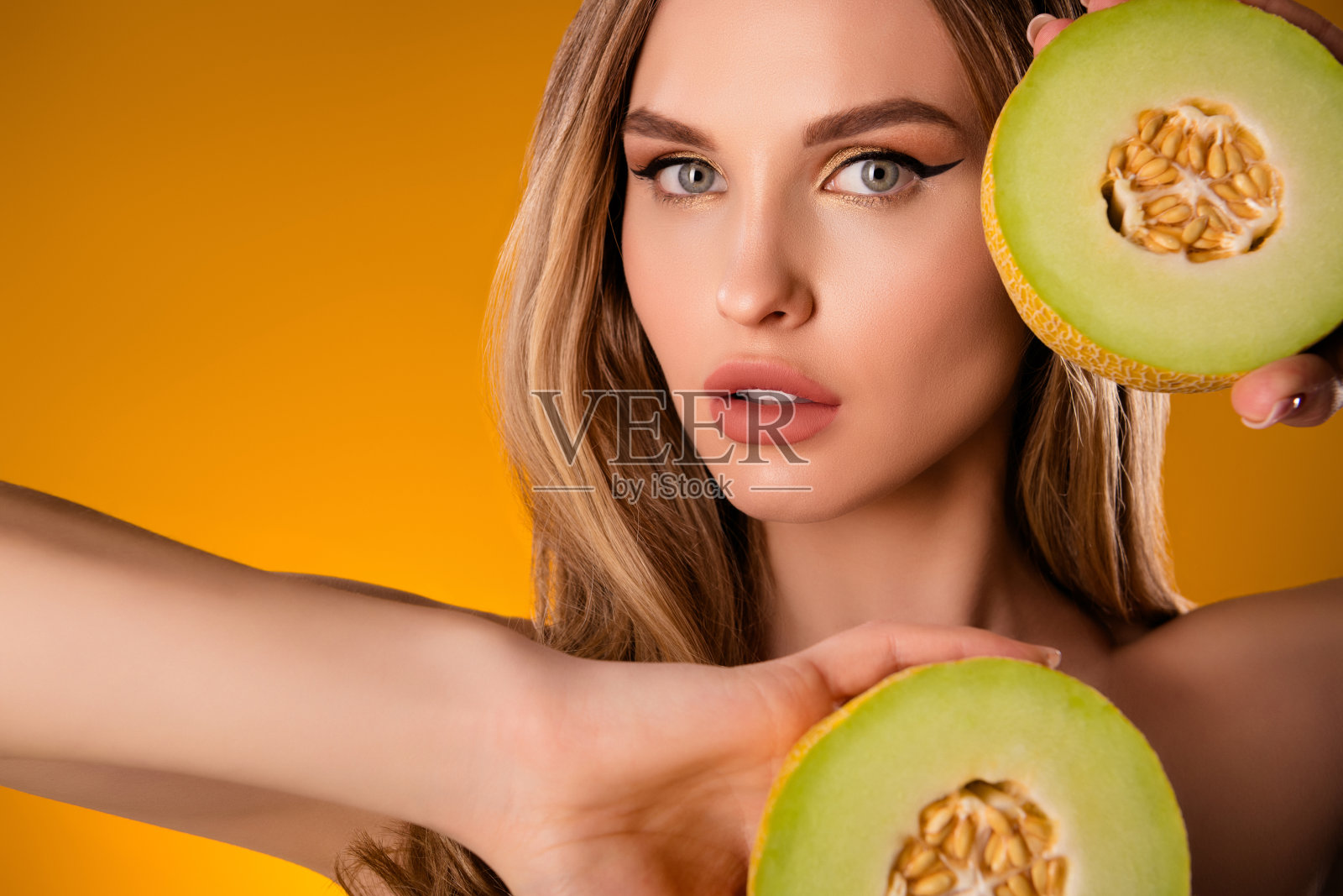 迷人可爱的漂亮女士在明亮的黄色背景上展示新鲜水果照片摄影图片