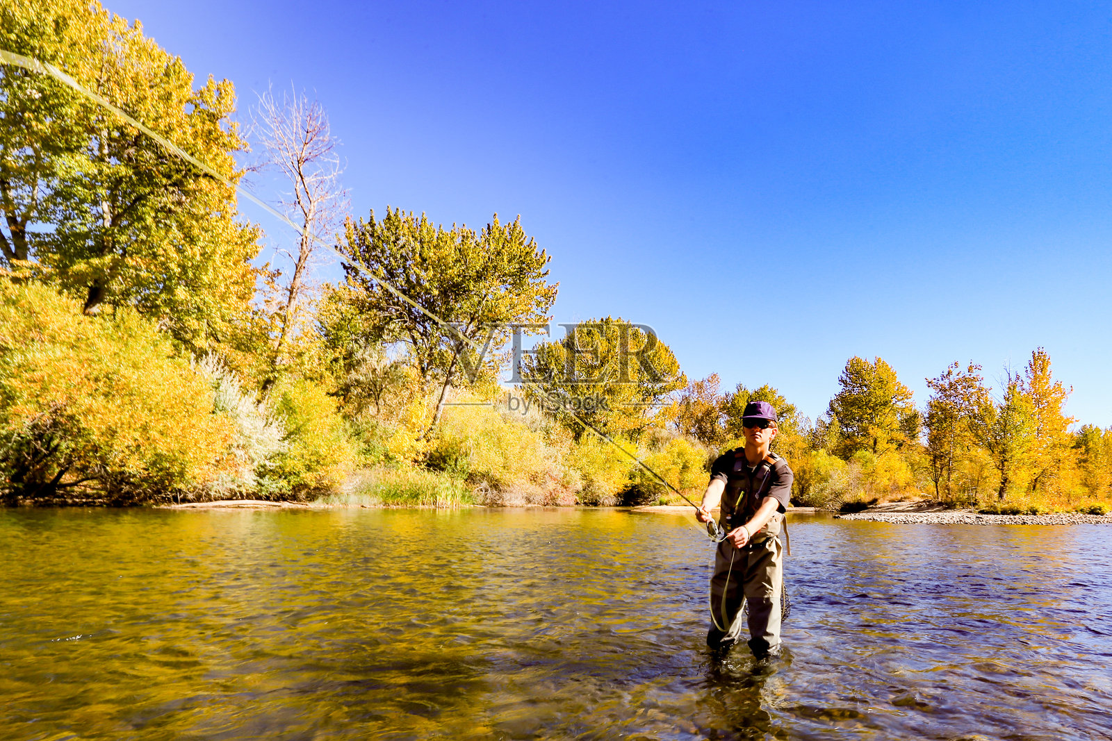 在爱达荷州博伊西的博伊西河上进行飞钓，享受美丽的秋日。照片摄影图片