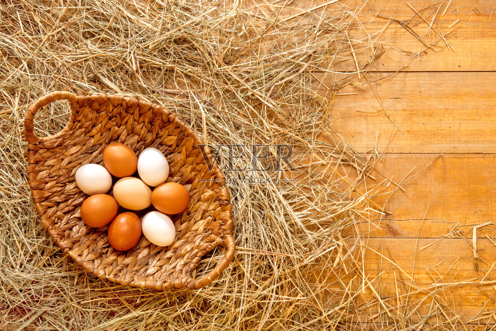 新鲜鸡蛋放在干草里的篮子里照片摄影图片
