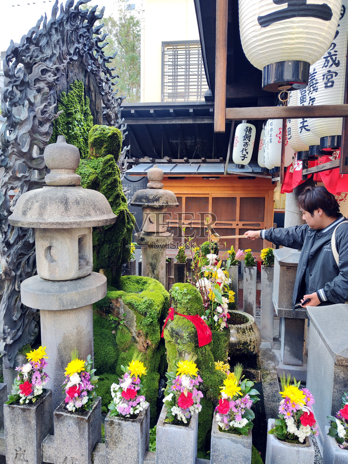 在日本大阪的法善寺,水掛不动像前的信徒照片摄影图片