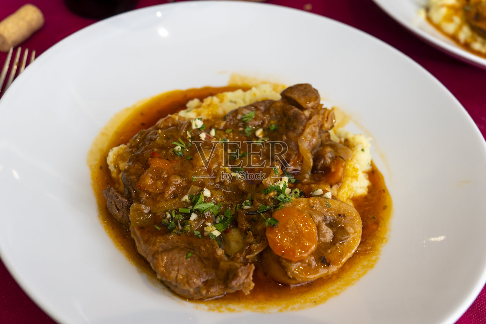 西班牙牛膝肉炖菜配蔬菜酱的盘子照片摄影图片